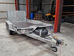 Side view of the orange Kubota M135