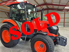 Side view of the orange tractor KUBOTA M7060