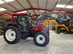 Side view of the red Valtra N91 tractor with other tractors in the background